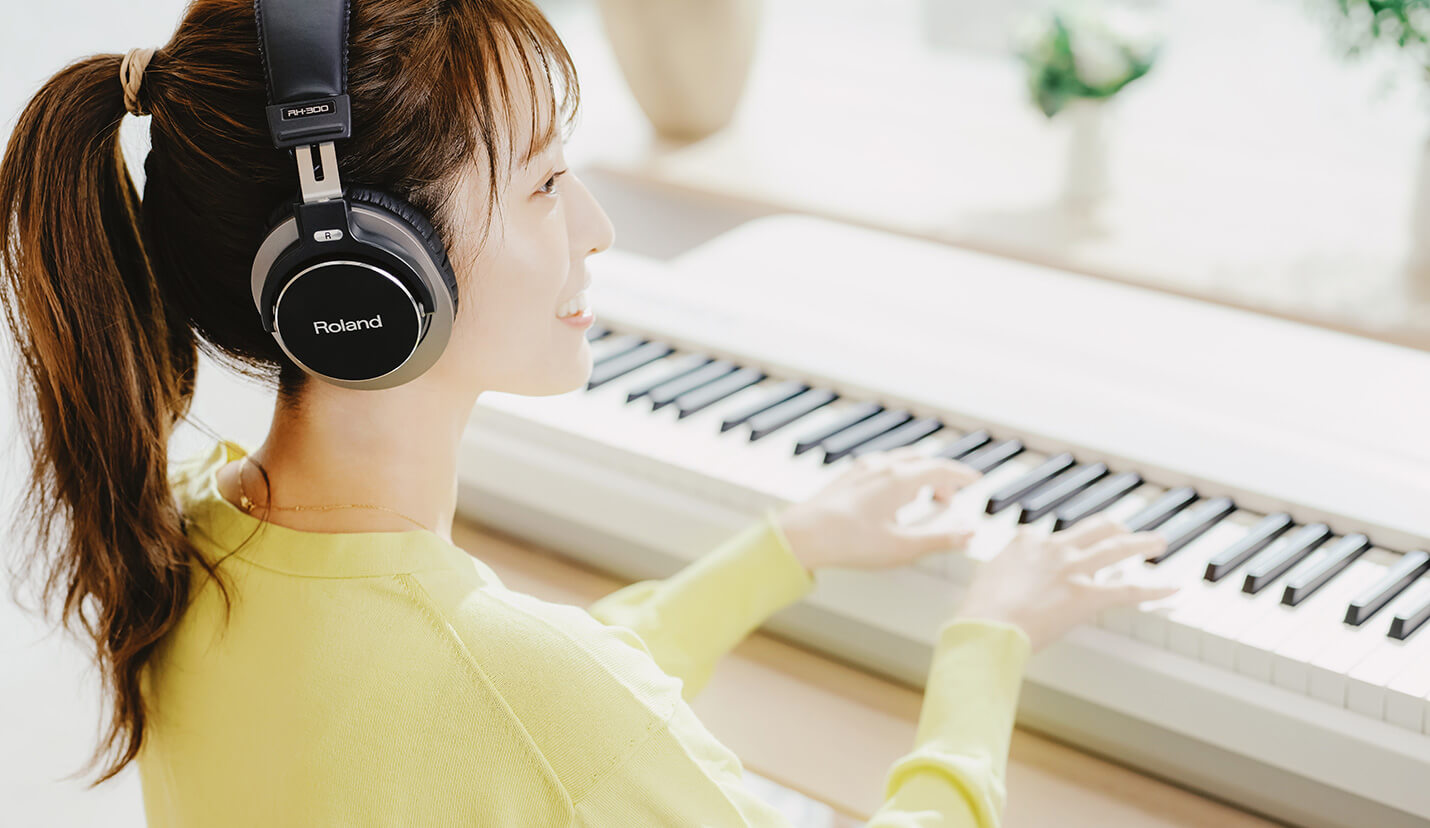 ヘッドホンでコンパクトな電子ピアノを弾く女性